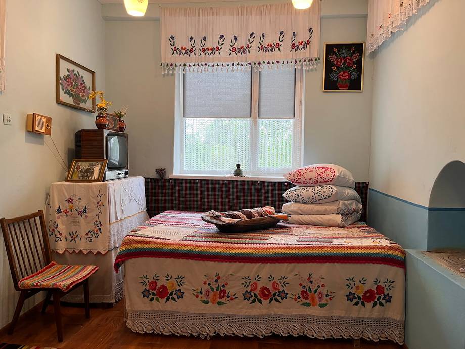 Vintage-style bedroom interior with floral bedspread and period furnishings