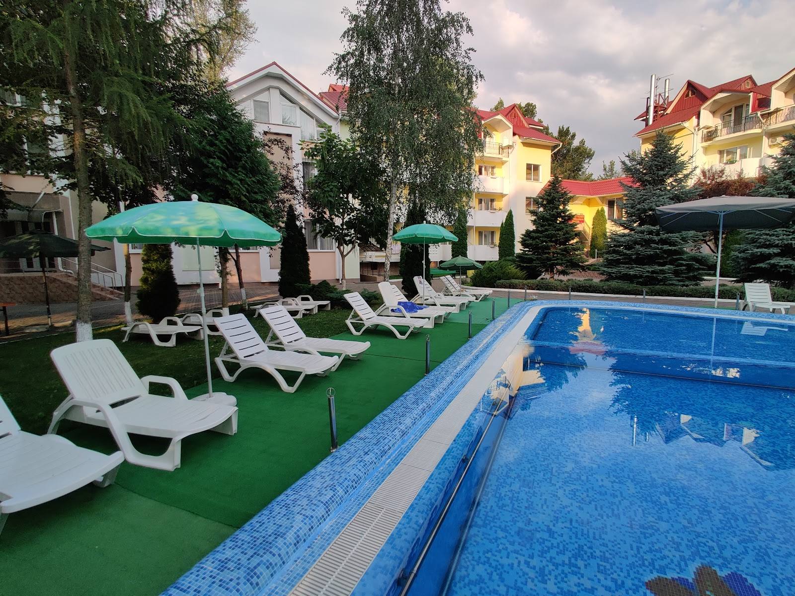 Resort pool area with loungers, umbrellas, and surrounding residential buildings