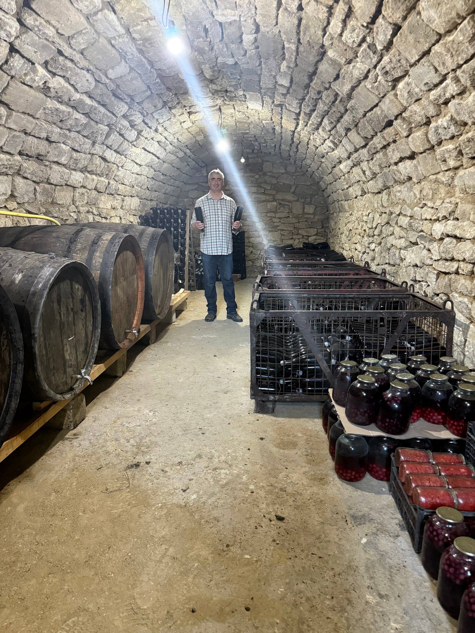 Wine cellar with wooden barrels and stone vaulted ceiling