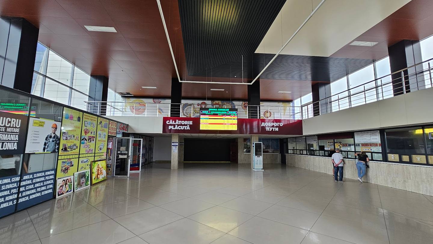 Modern transit hub interior with check-in counters and passenger seating area
