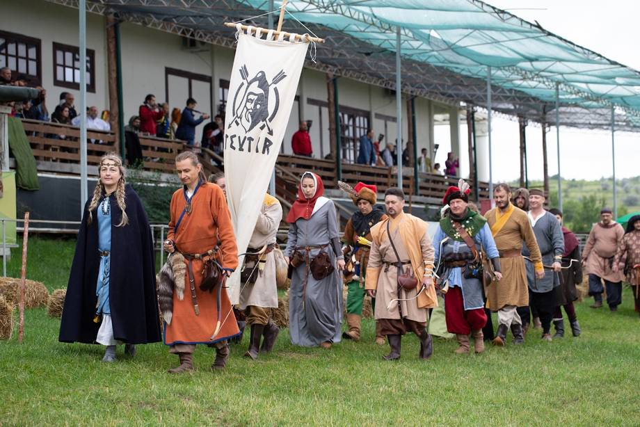 Medieval festival participants in traditional costumes at an outdoor event venue