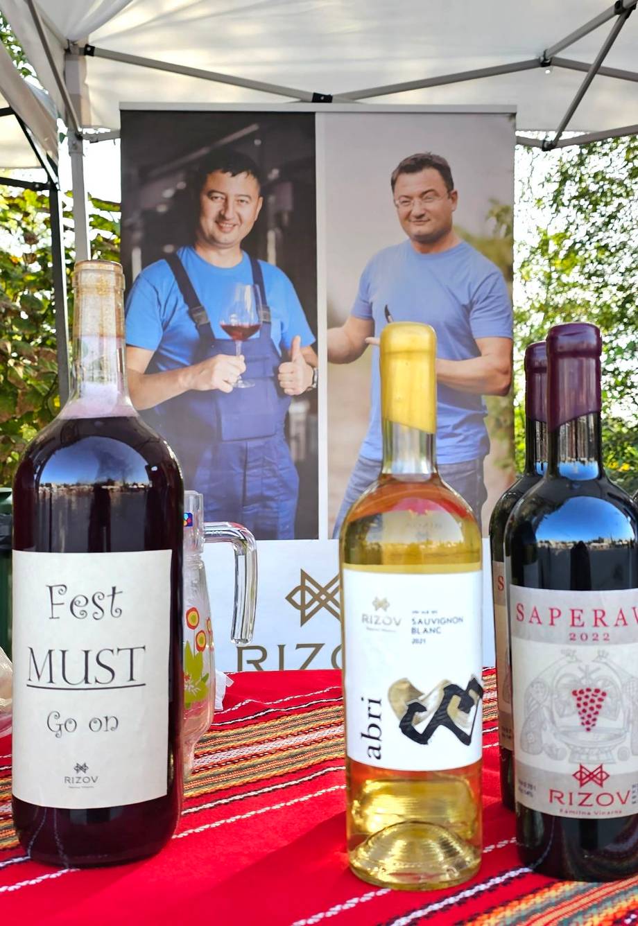 Wine bottles and branded merchandise displayed at outdoor vendor booth