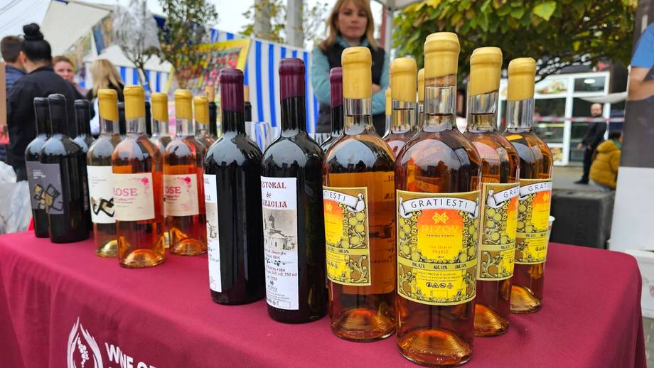 Wine tasting event with bottles displayed on table at outdoor venue