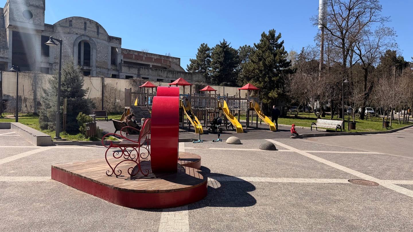Public park with playground and historic building facade in background