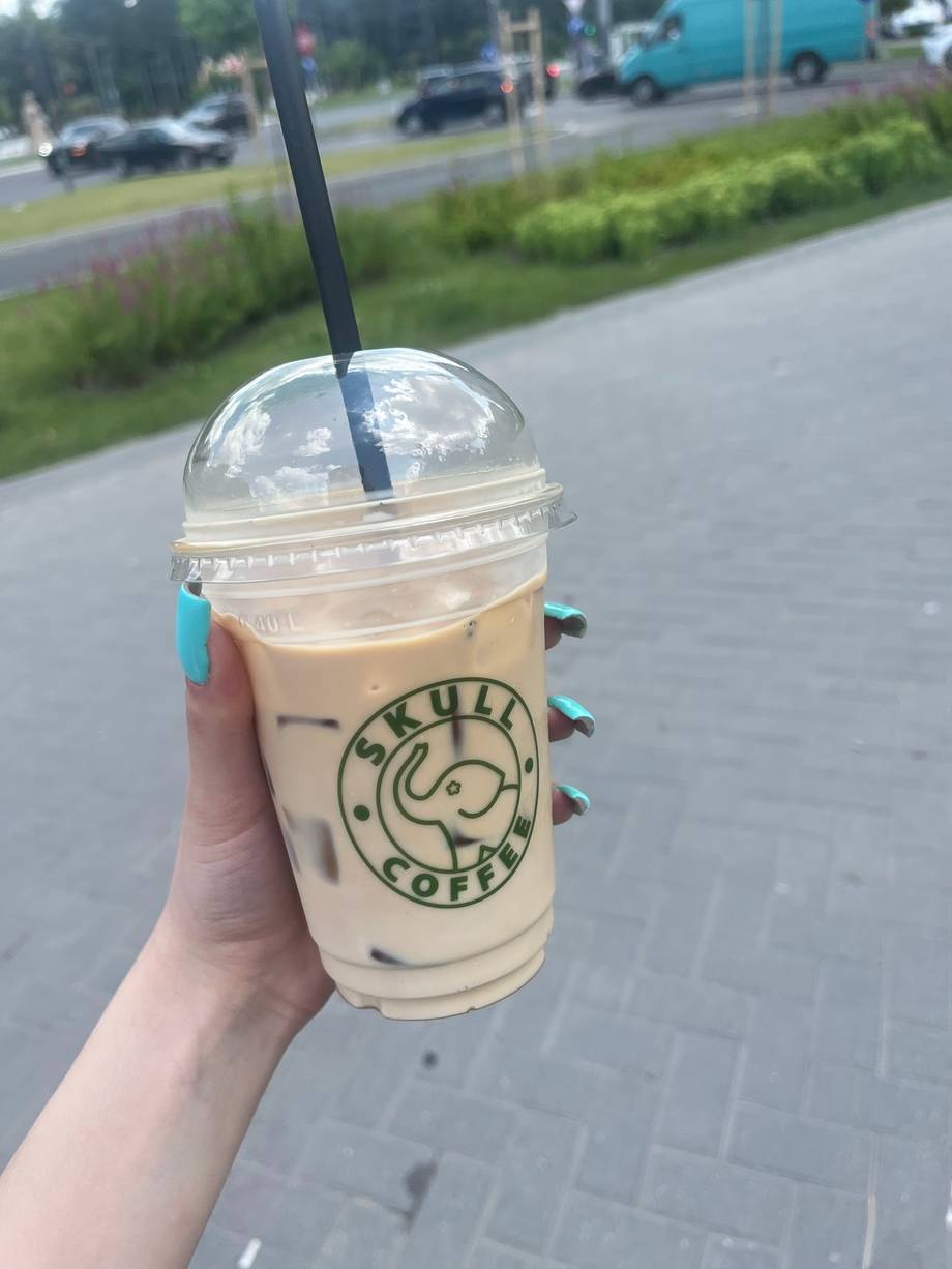 Iced coffee beverage with Buskala Coffee branding in hand outdoors