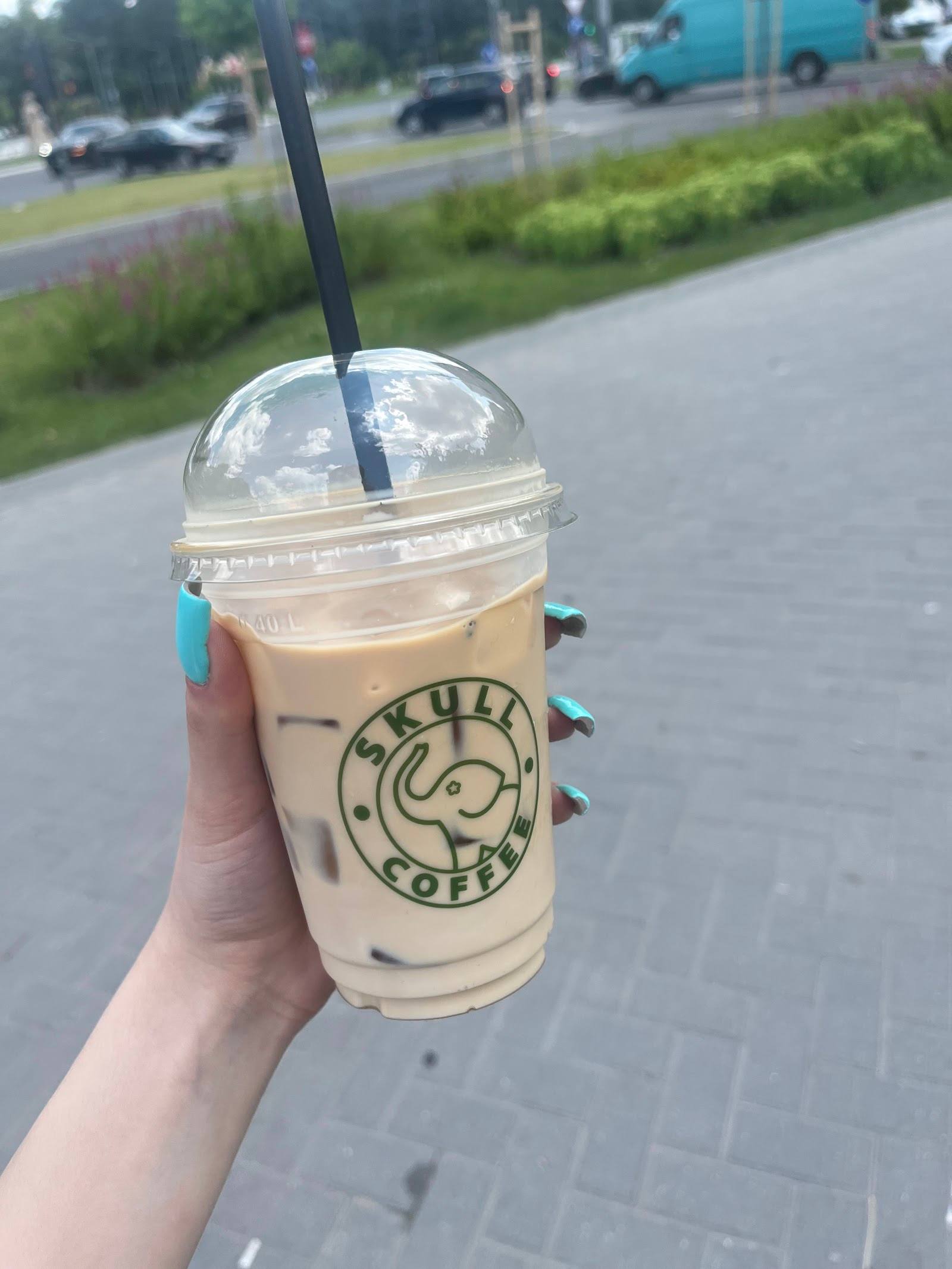 Iced coffee beverage with Buskala Coffee branding in hand outdoors