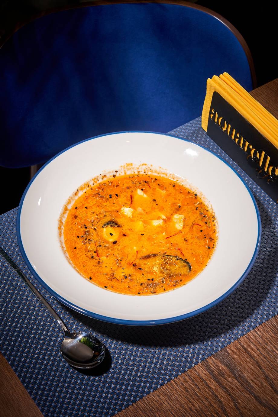 Creamy tomato soup with croutons and herbs in white bowl at Florarella restaurant