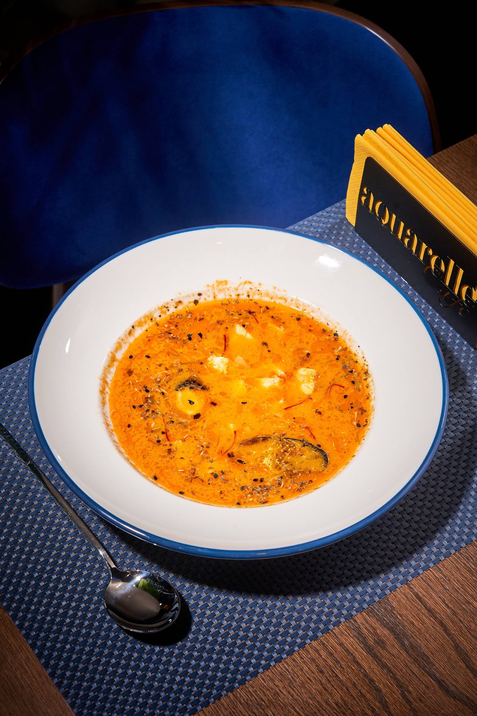 Creamy tomato soup with croutons and herbs in white bowl at Florarella restaurant