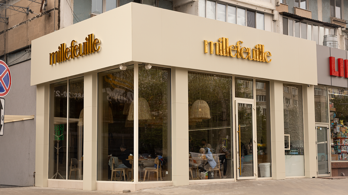 Modern storefront facade with mille-feuille branding and large windows showing interior seating