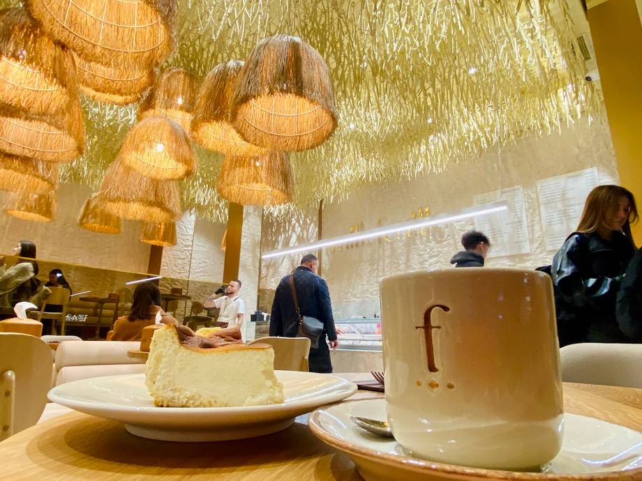 Dessert plate with tea service in modern cafe interior with woven pendant lights