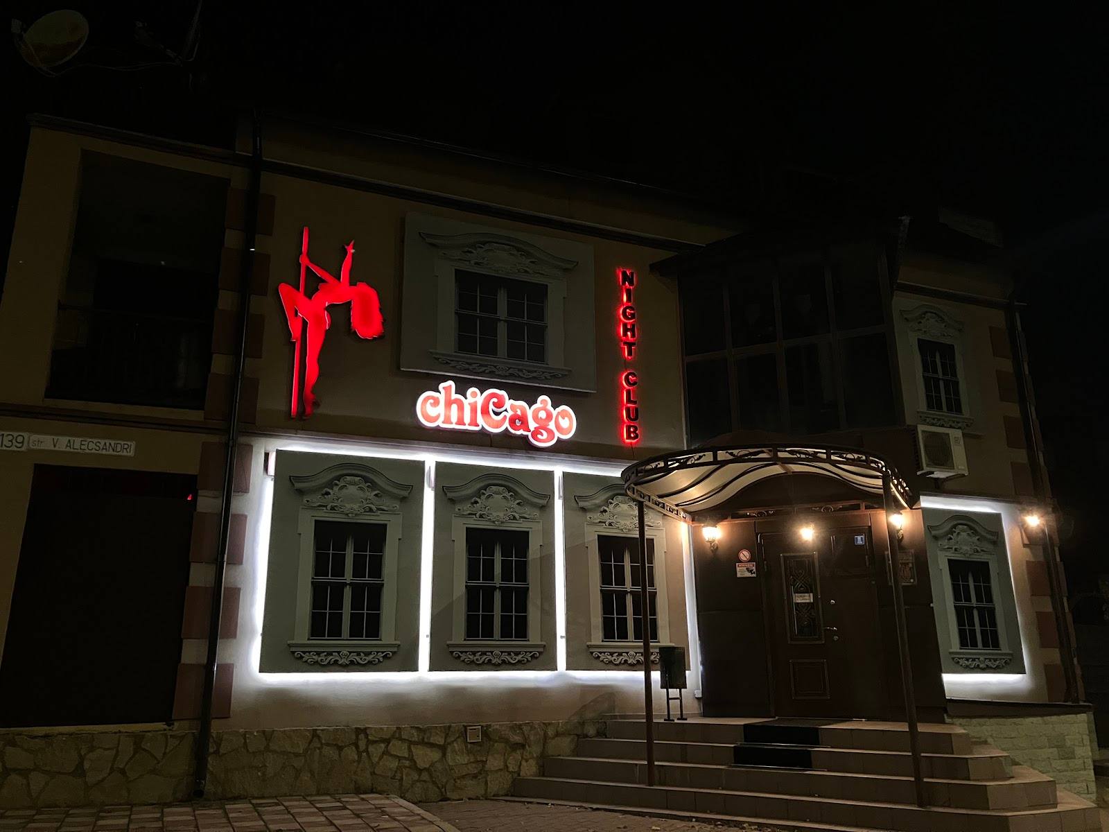 Night-lit club storefront with red neon signage and illuminated entrance