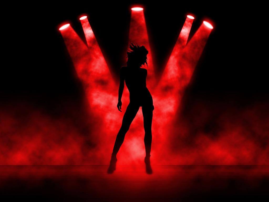 Silhouetted performer dancing in dramatic red stage lighting