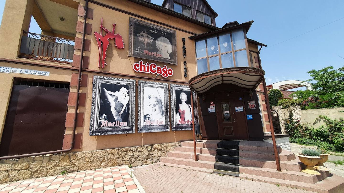 Chicage nightclub facade with signage, stone entrance, and brick courtyard