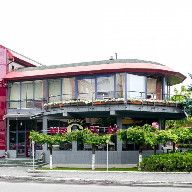 Modern curved facade restaurant with signage, street frontage and vegetation