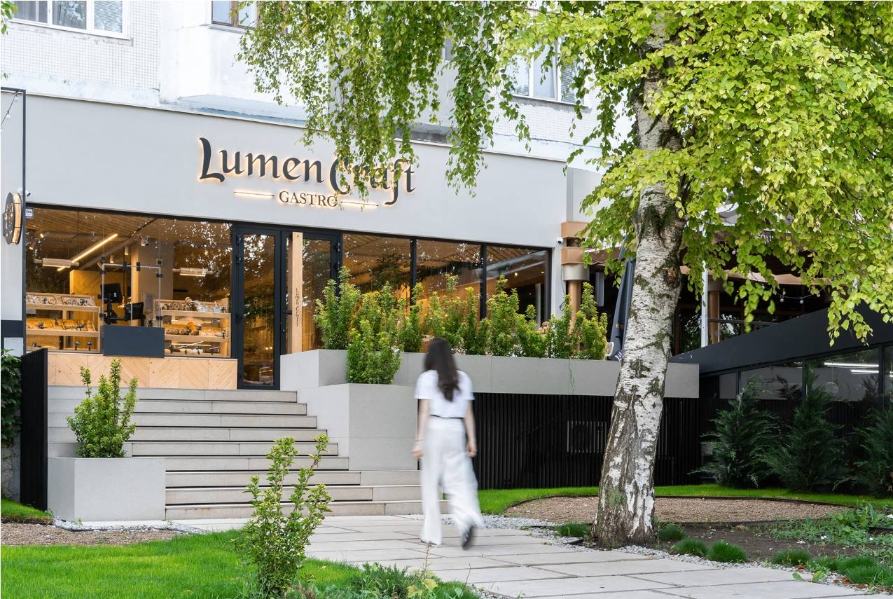 Lumencafé storefront with modern façade, street-level entrance, and landscaped courtyard