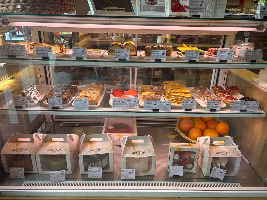 Bakery display case with pastries, cakes, and packaged goods