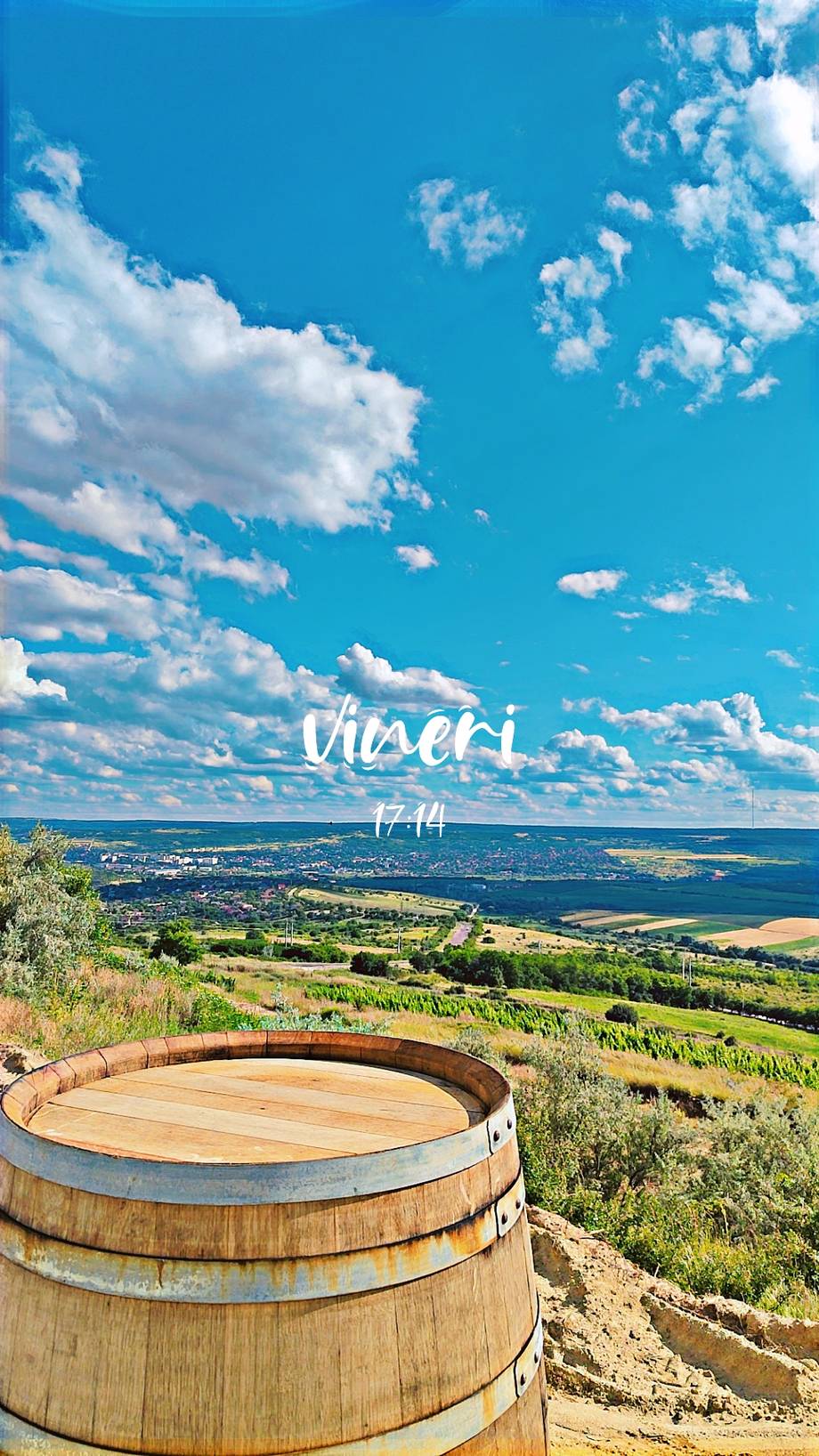 Wine barrel overlooking Niseri vineyard valley landscape with rolling fields