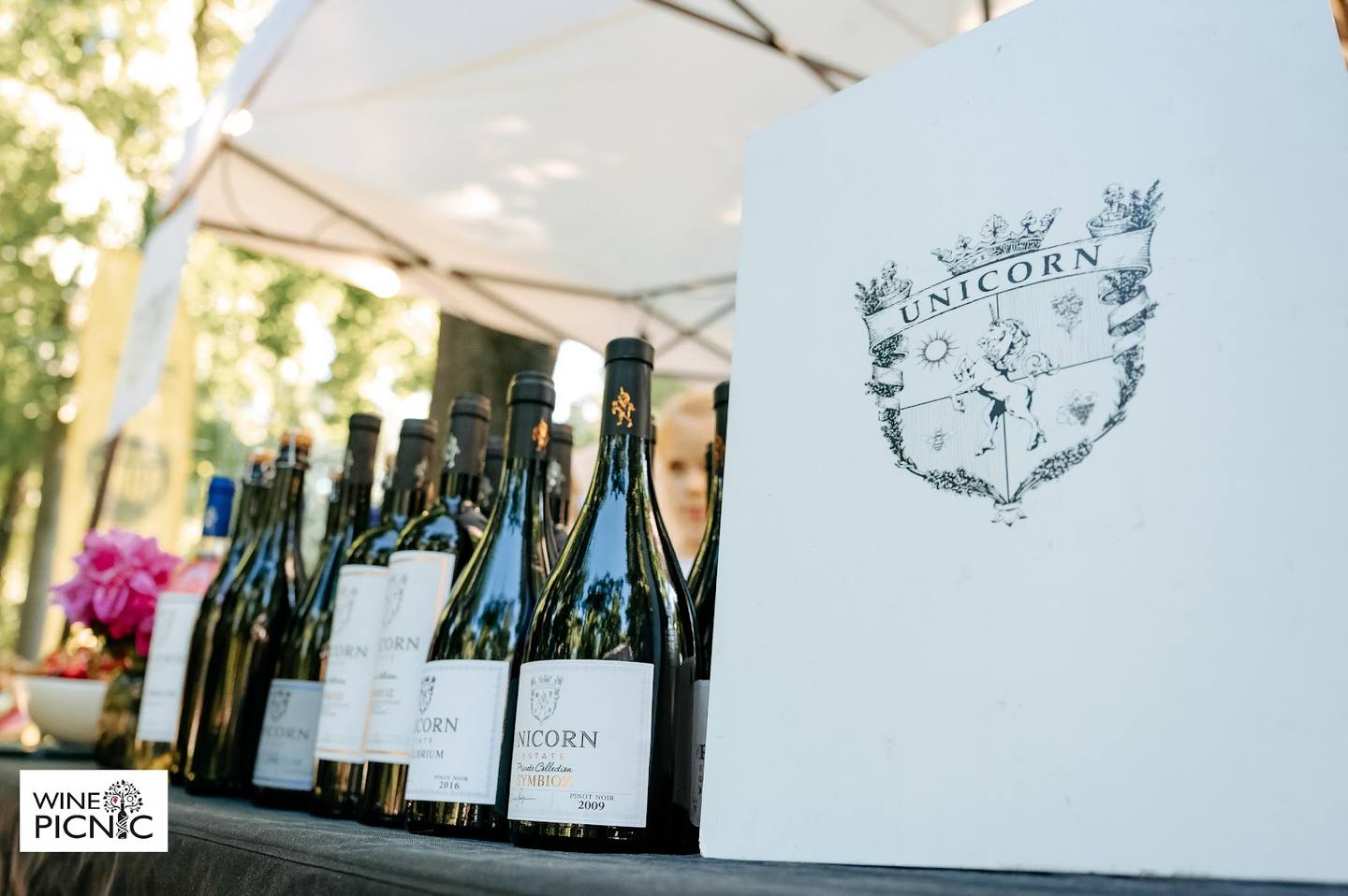 Wine bottles displayed with vineyard branding at an outdoor event or tasting