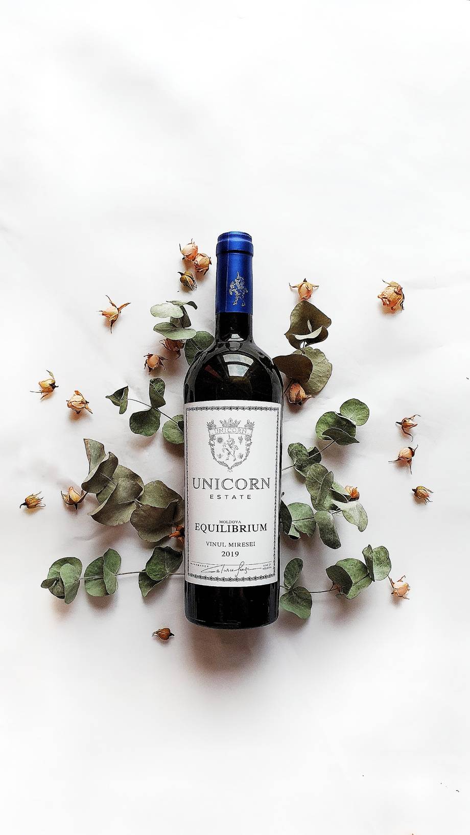 Unicorn Estate wine bottle styled with dried florals and eucalyptus on white background