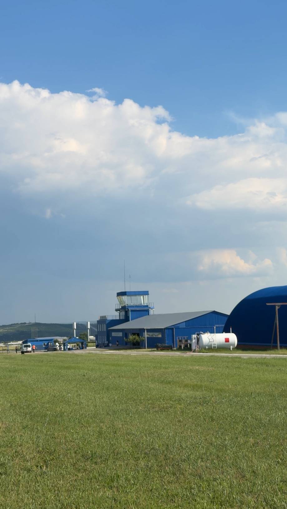 Airfield with blue hangar buildings and runway strip in rural Moldova