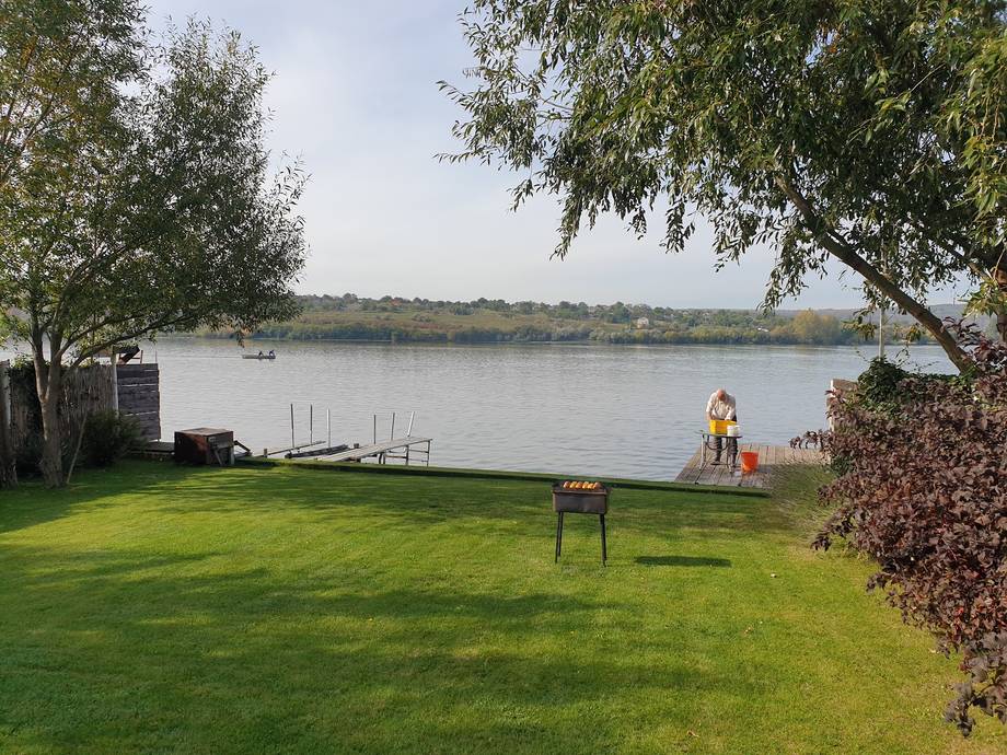 Riverside terrace with manicured lawn, boat dock, and water views