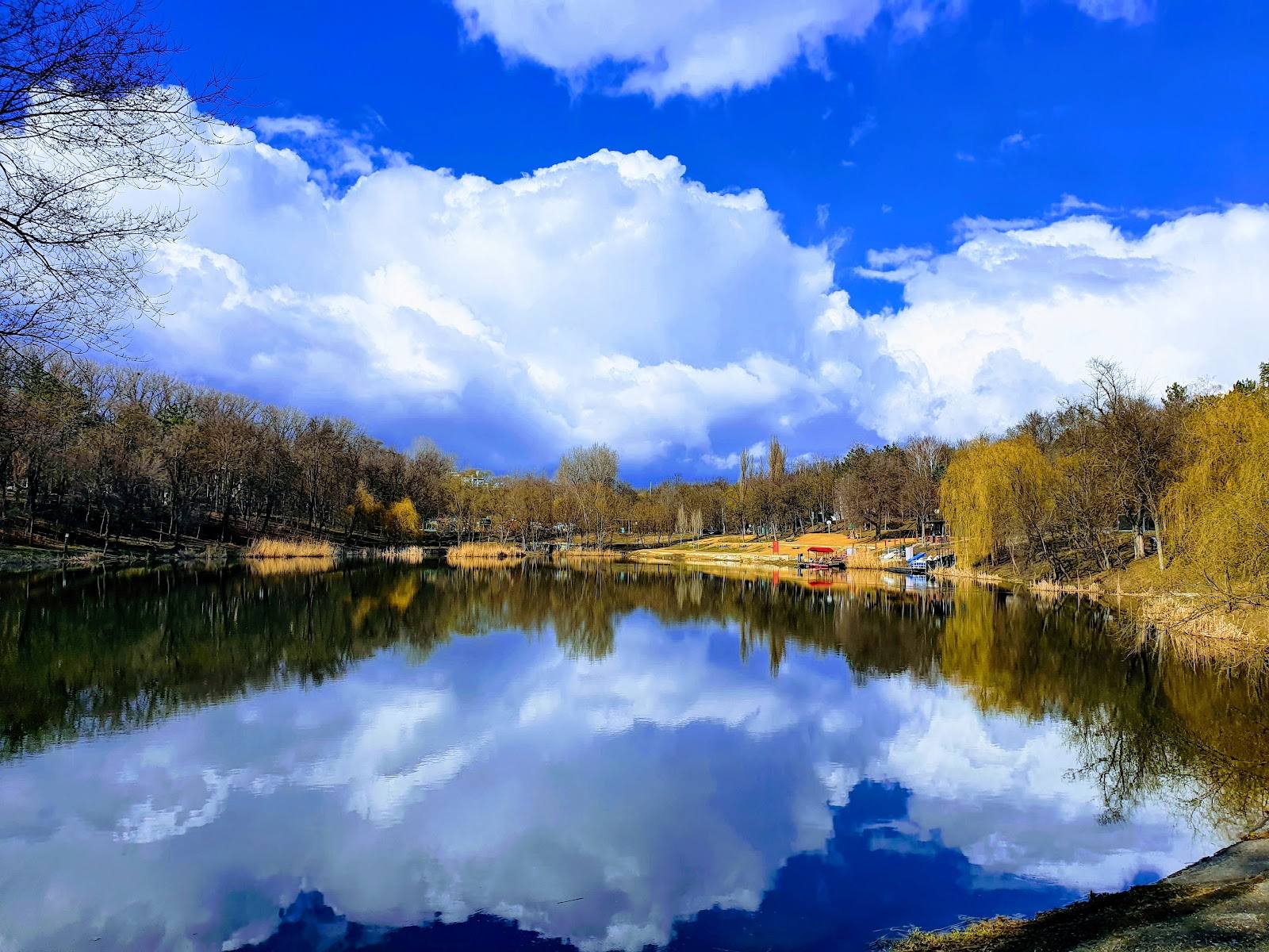 Riverside landscape with autumn trees and blue sky reflection