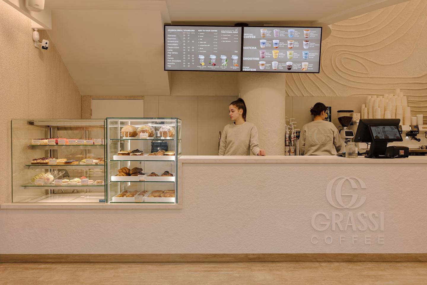 Grassi café storefront with minimalist beige interior, counter service, and menu boards