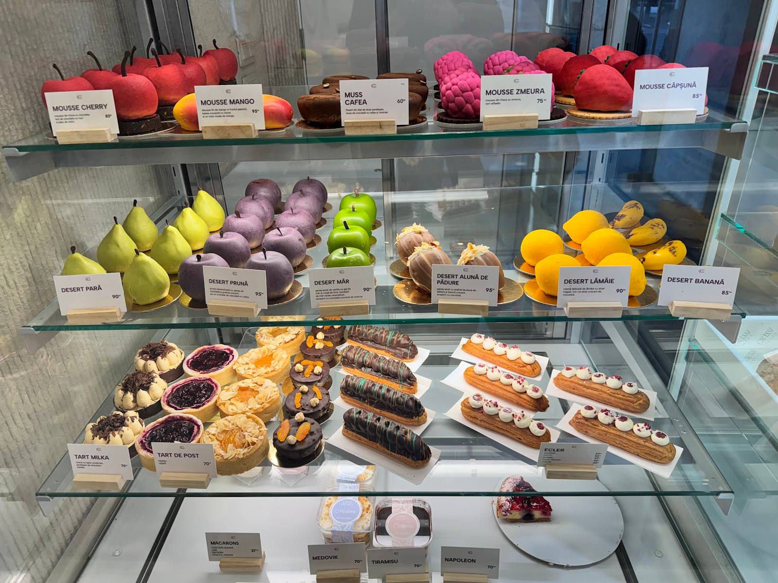 Bakery display case with colorful pastries, cakes, and fresh fruit desserts