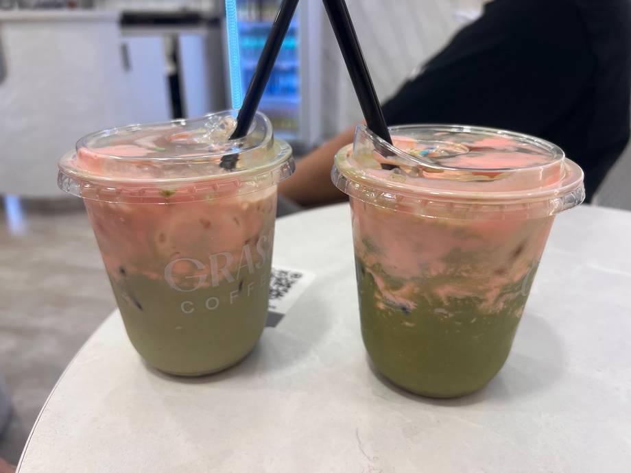 Pair of matcha drinks with tapioca pearls and black straws