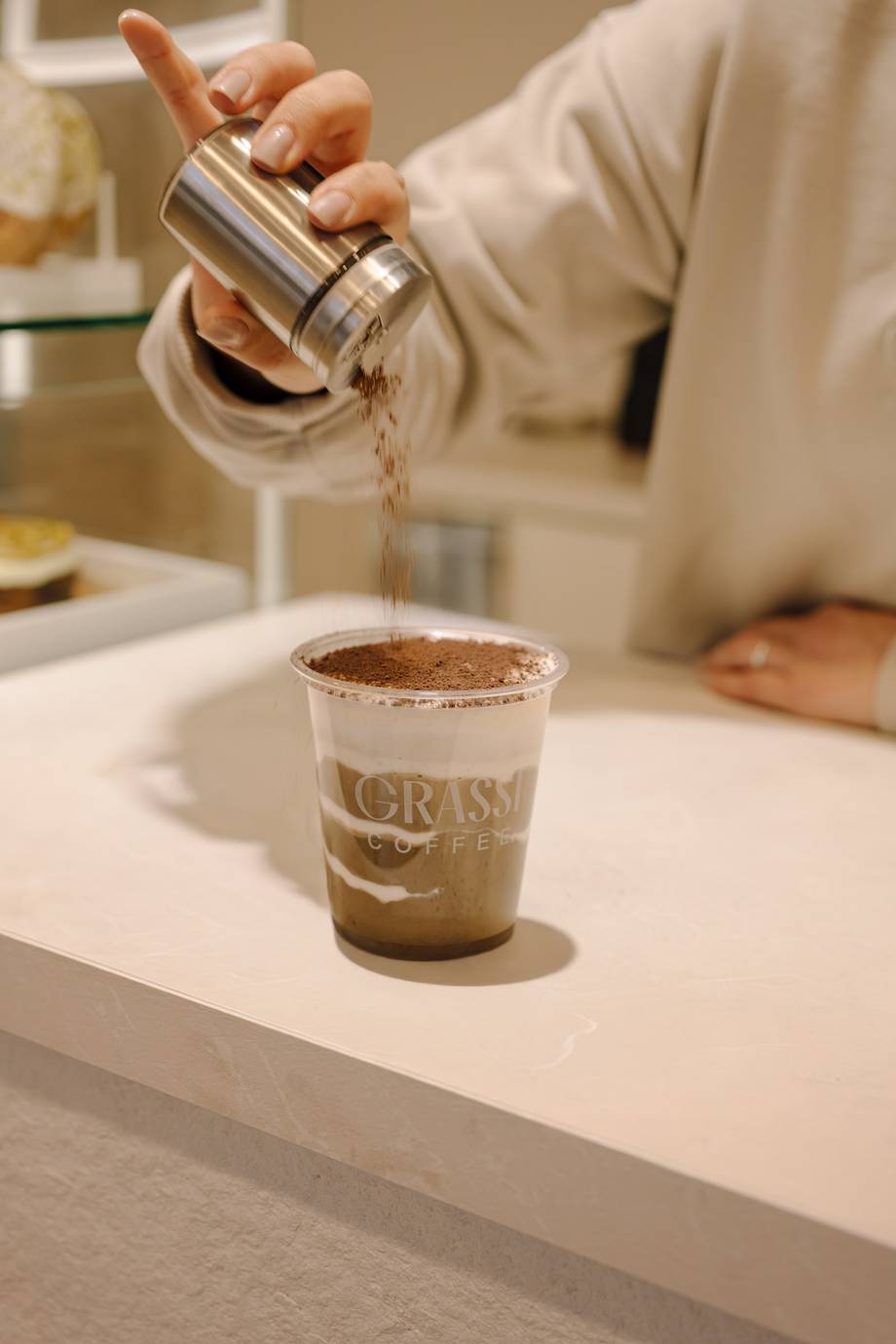 Barista pouring syrup into a branded coffee beverage at the counter