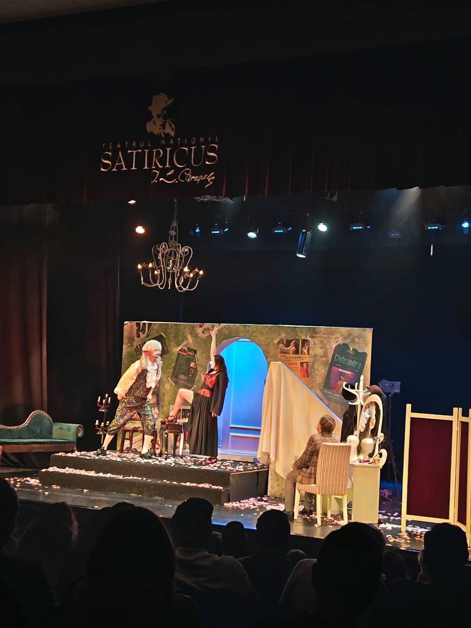 Theater performance at Satiricus club with ornate chandelier and stage set