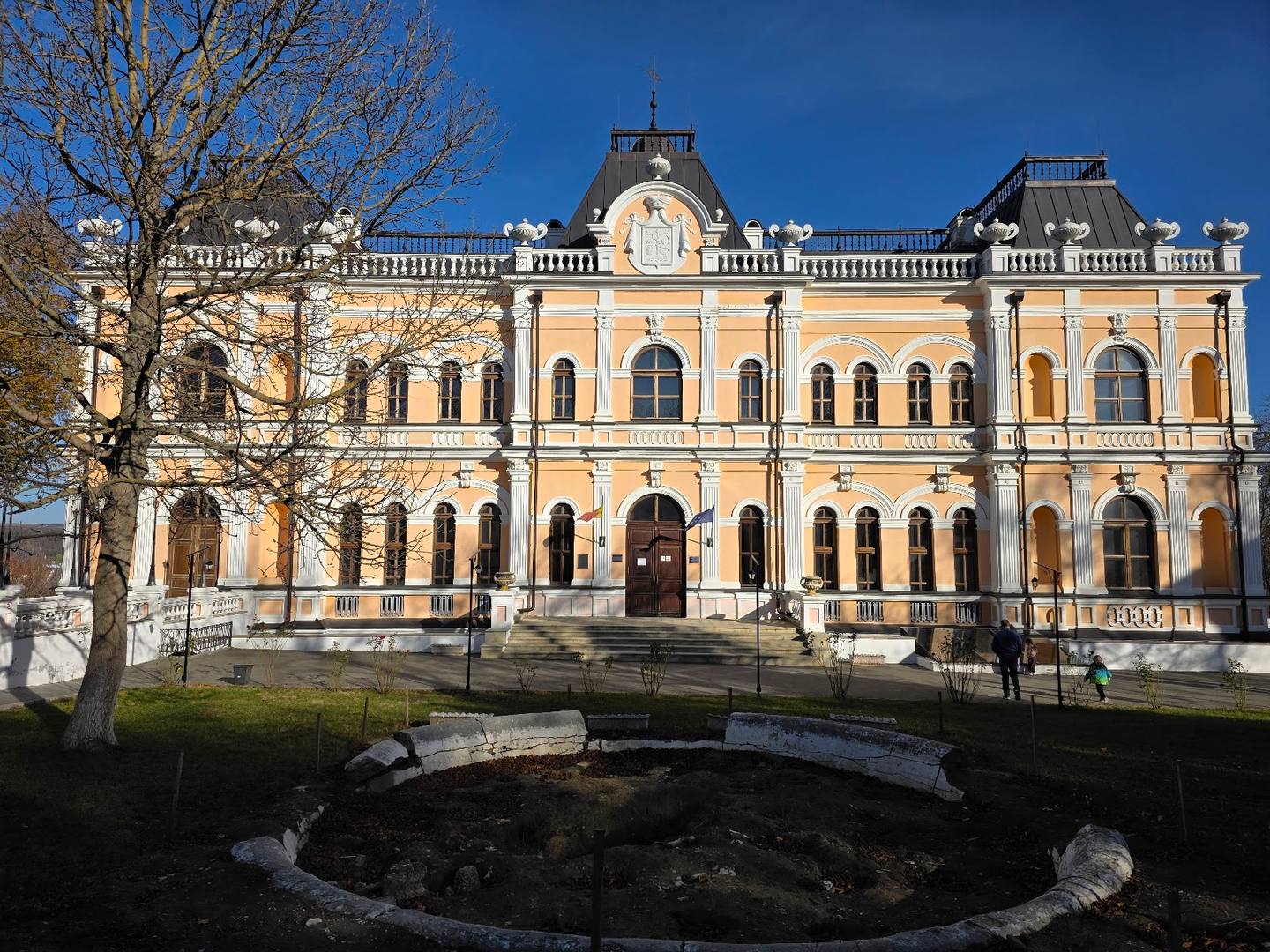 Classical architecture facade with ornate cream-colored palazzo building and manicured grounds