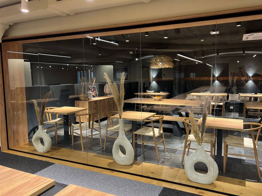 Modern cafe interior with wood tables, minimalist decor, and floor-to-ceiling windows
