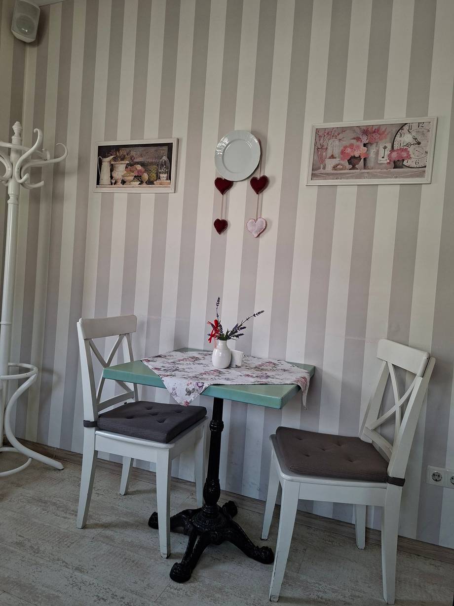 Small table corner with striped wallpaper and bistro seating
