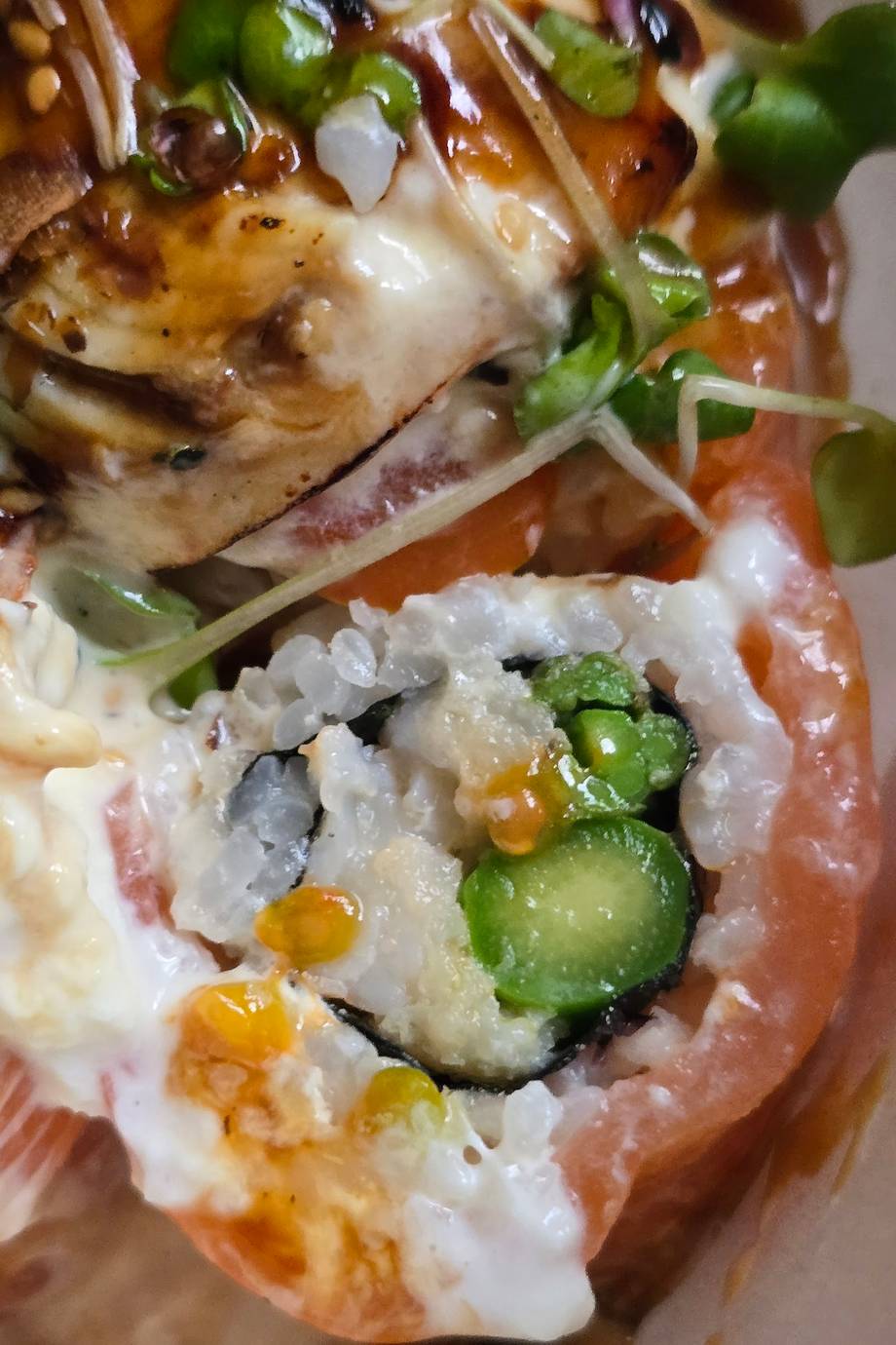 Sushi rolls with avocado, cucumber, and roe on wooden plate