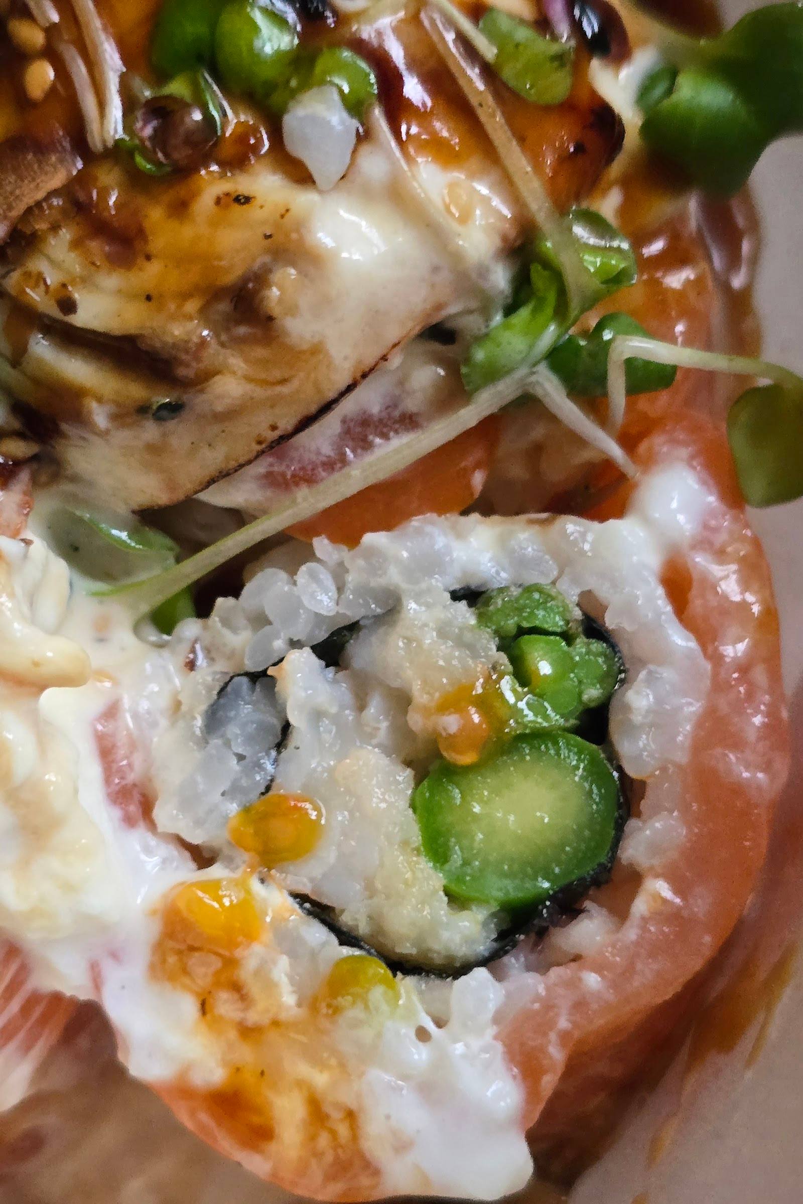 Sushi rolls with avocado, cucumber, and roe on wooden plate