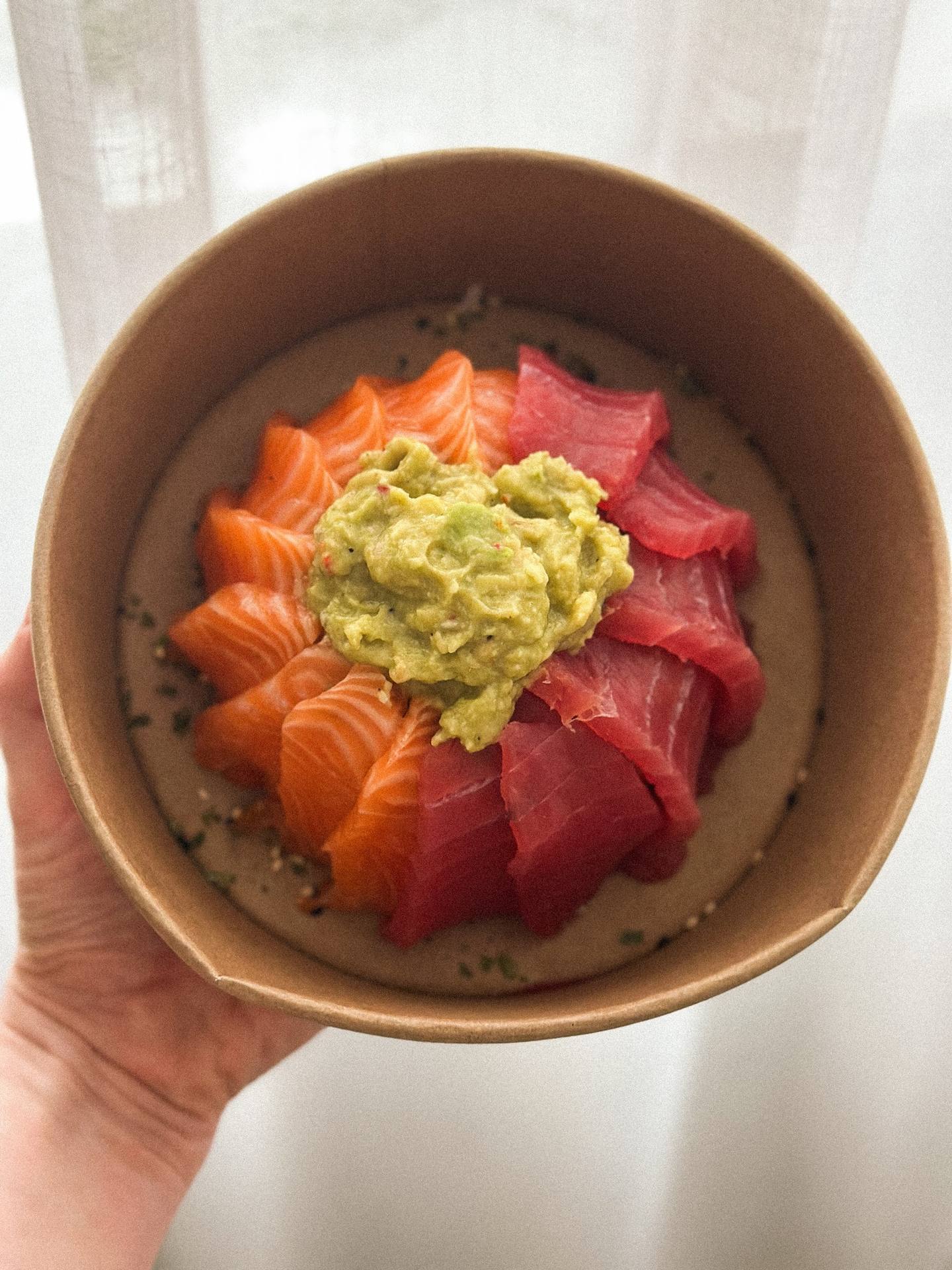 Poke bowl with salmon, tuna, avocado and sesame seeds