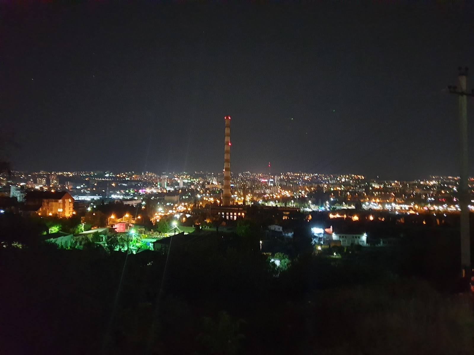 Night cityscape with illuminated tower and distant city lights