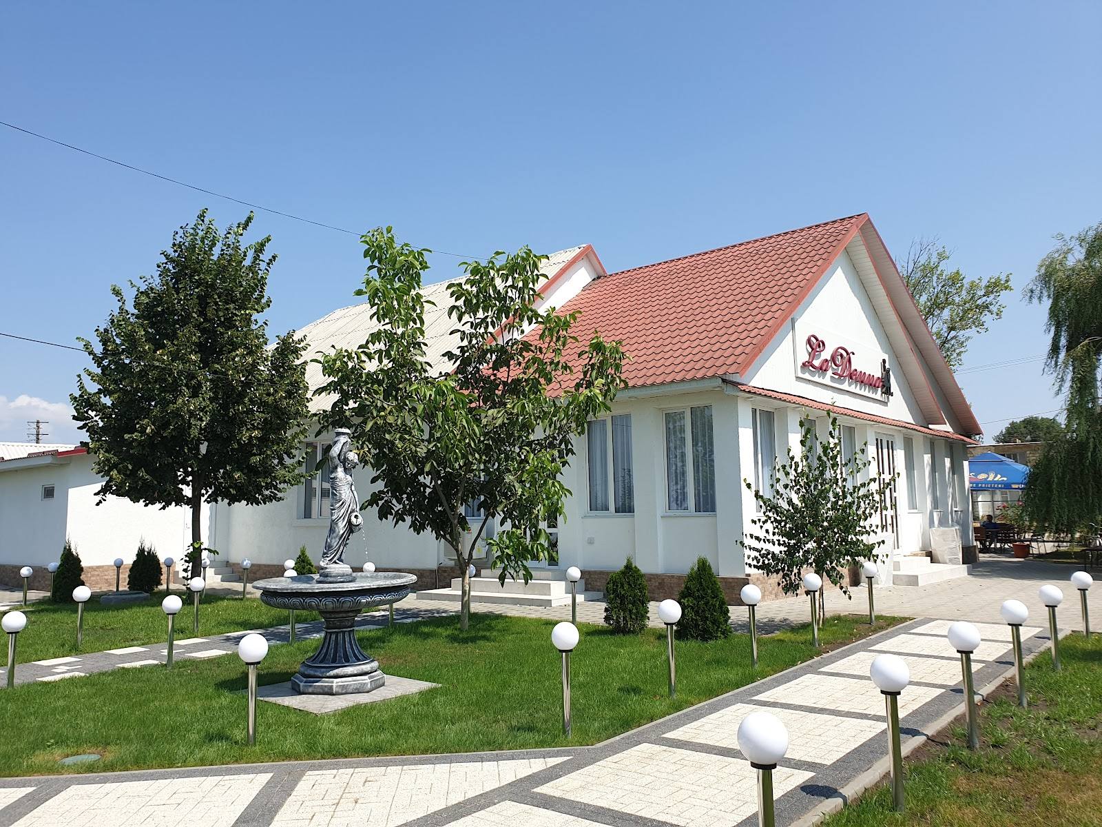 White chapel with red roof, manicured grounds and pathway