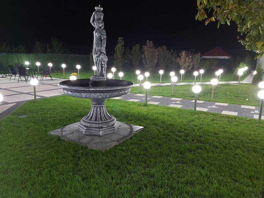 Illuminated statue and grounds of Orthodox monastery at night, Moldova