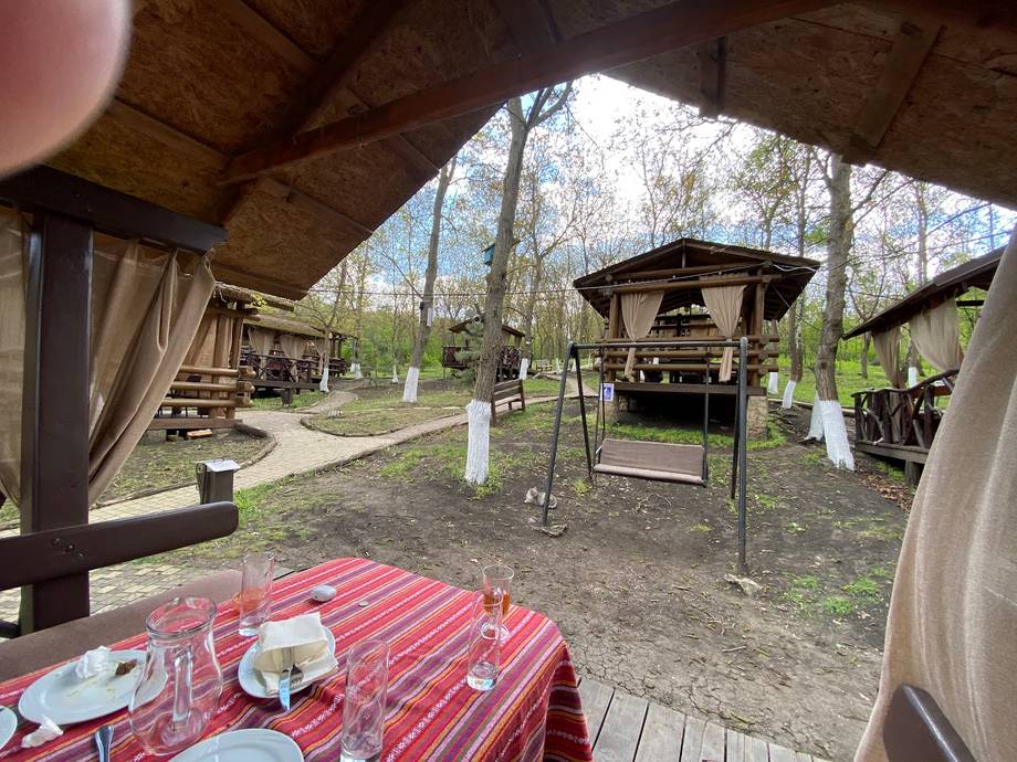 Rustic outdoor terrace with traditional gazebos and red checkered tablescape
