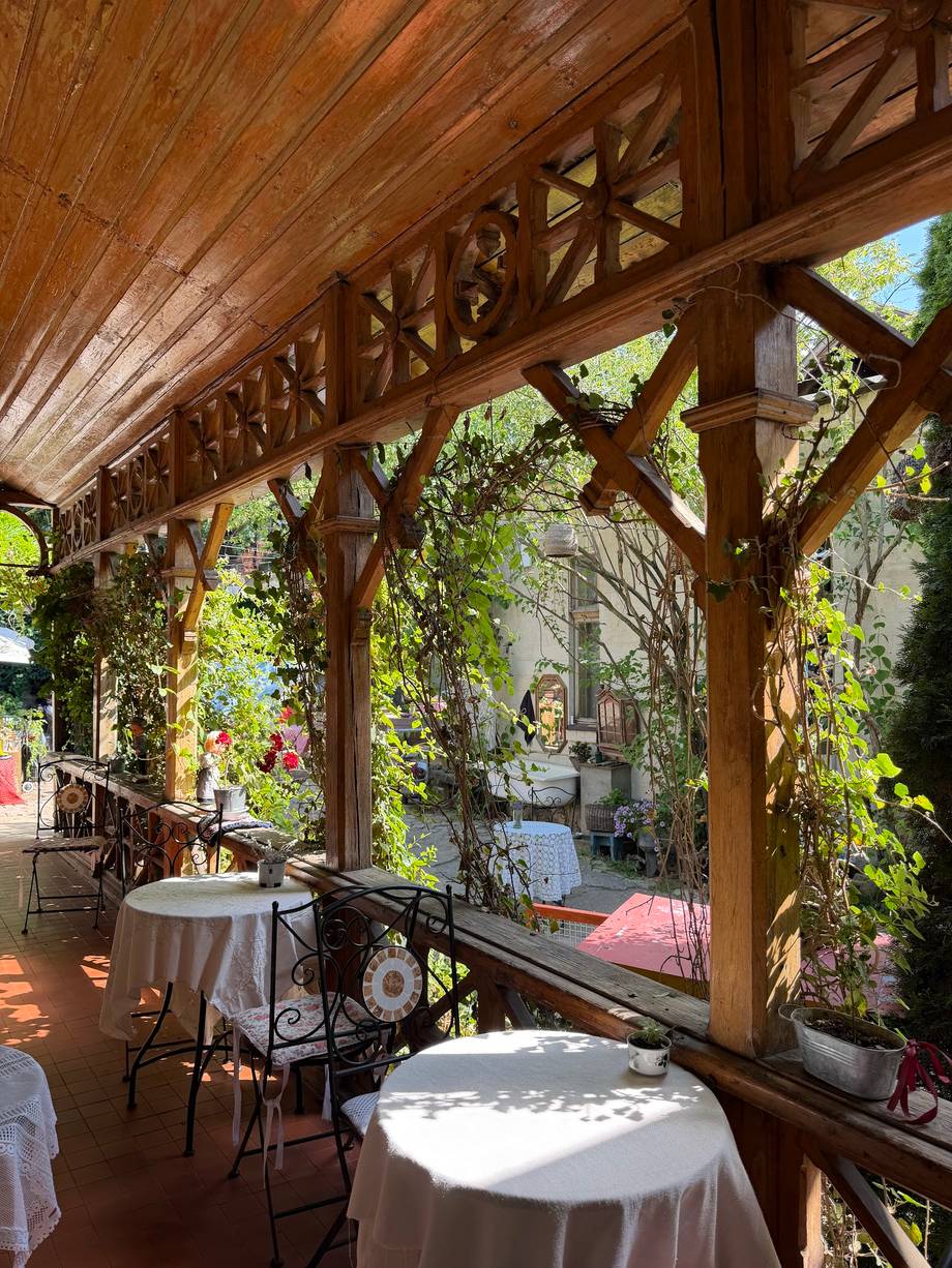 Elegant wooden pergola terrace with ivy-covered walls and intimate dining setup