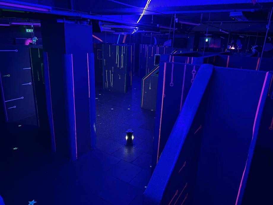 Laser tag arena with neon blue walls and elevated gameplay platforms