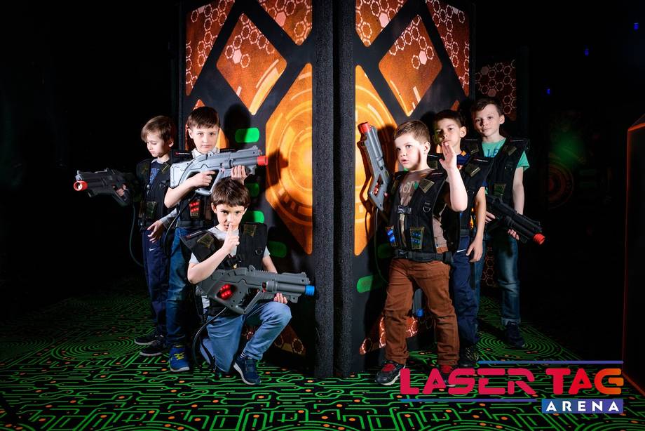 Players in tactical gear during laser tag game at Laser Tag Arena with illuminated fortress backdrop