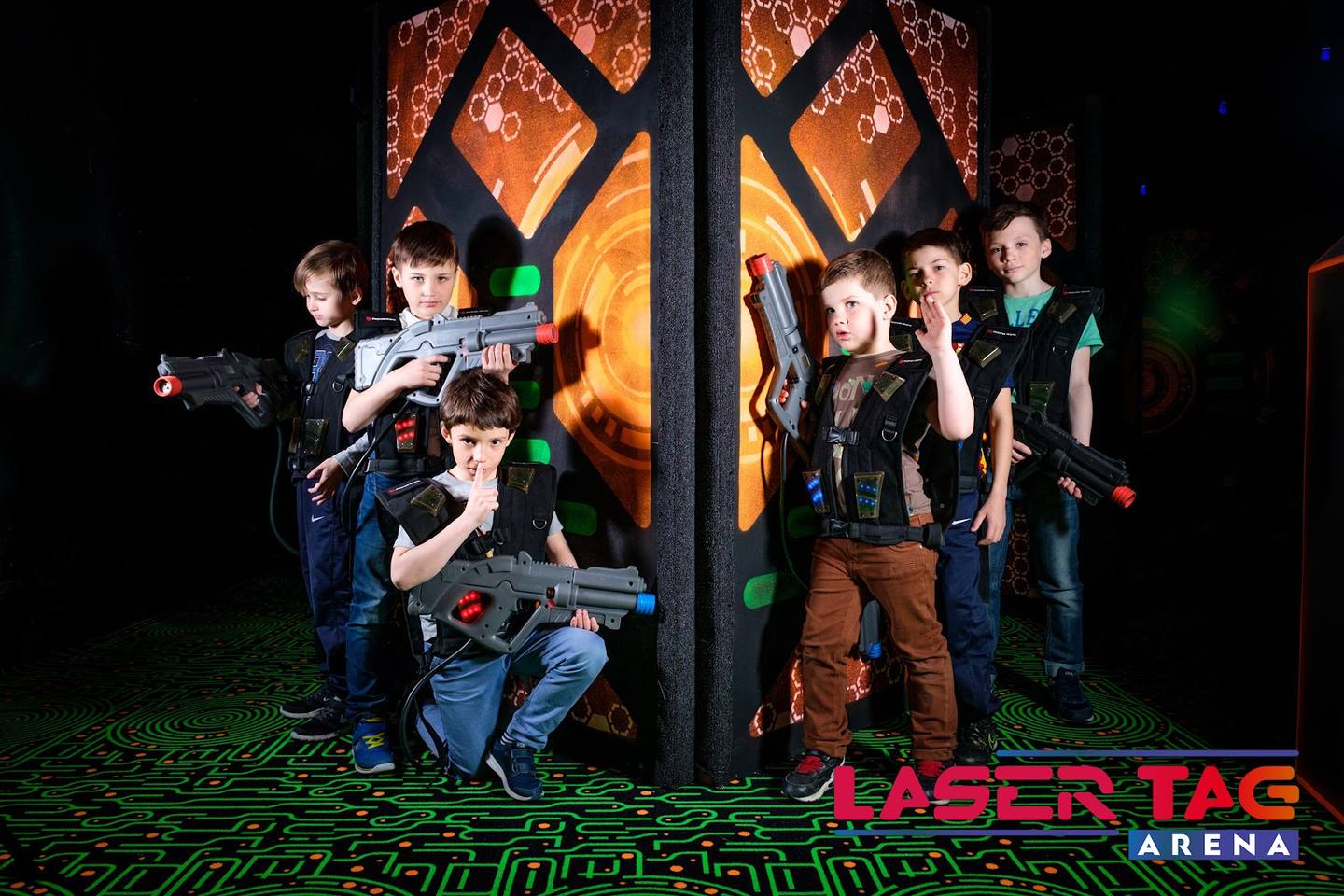 Players in tactical gear during laser tag game at Laser Tag Arena with illuminated fortress backdrop