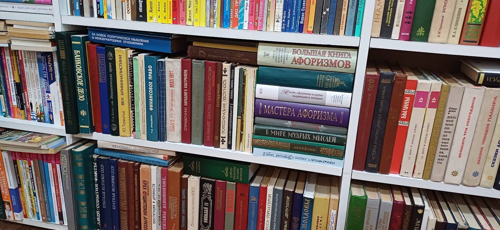 Library or bookstore shelving with colorful books organized across white shelves