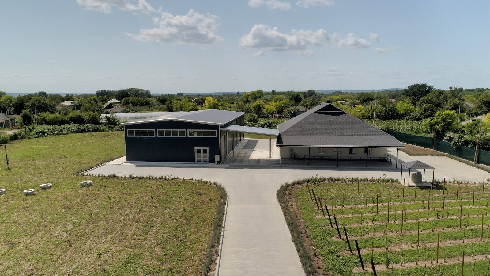 Modern winery buildings with vineyard rows and rolling landscape