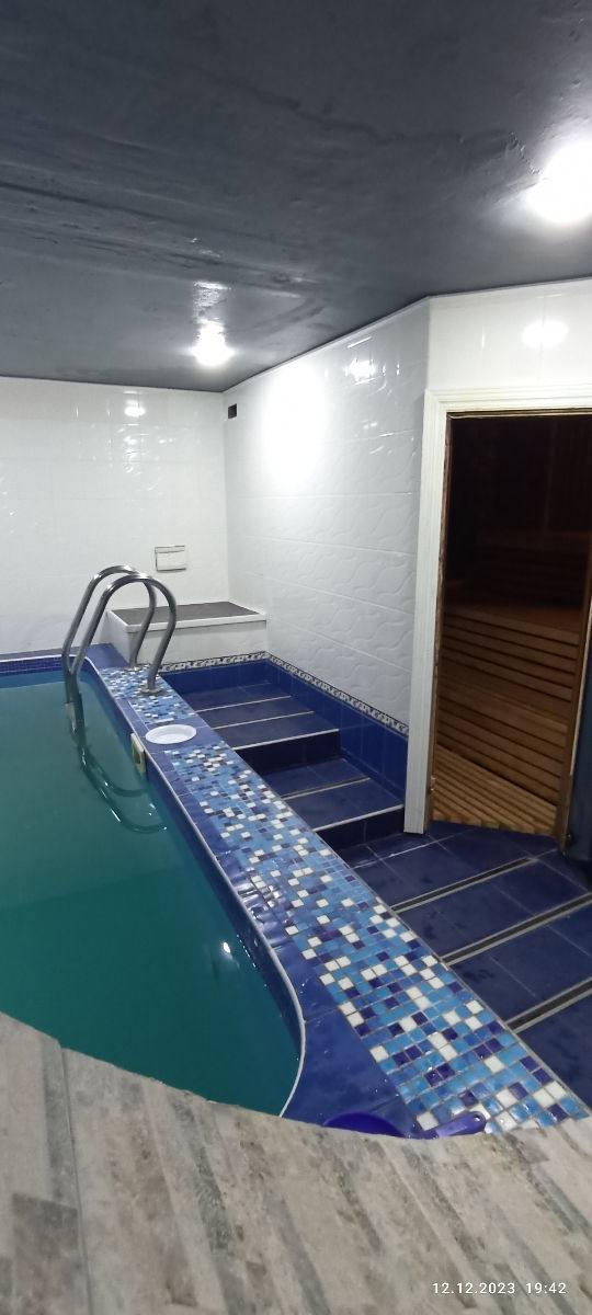 Indoor swimming pool with blue tiled edge and white brick walls
