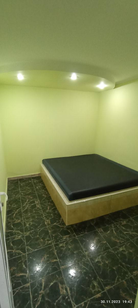 Minimalist treatment room with massage table and recessed lighting