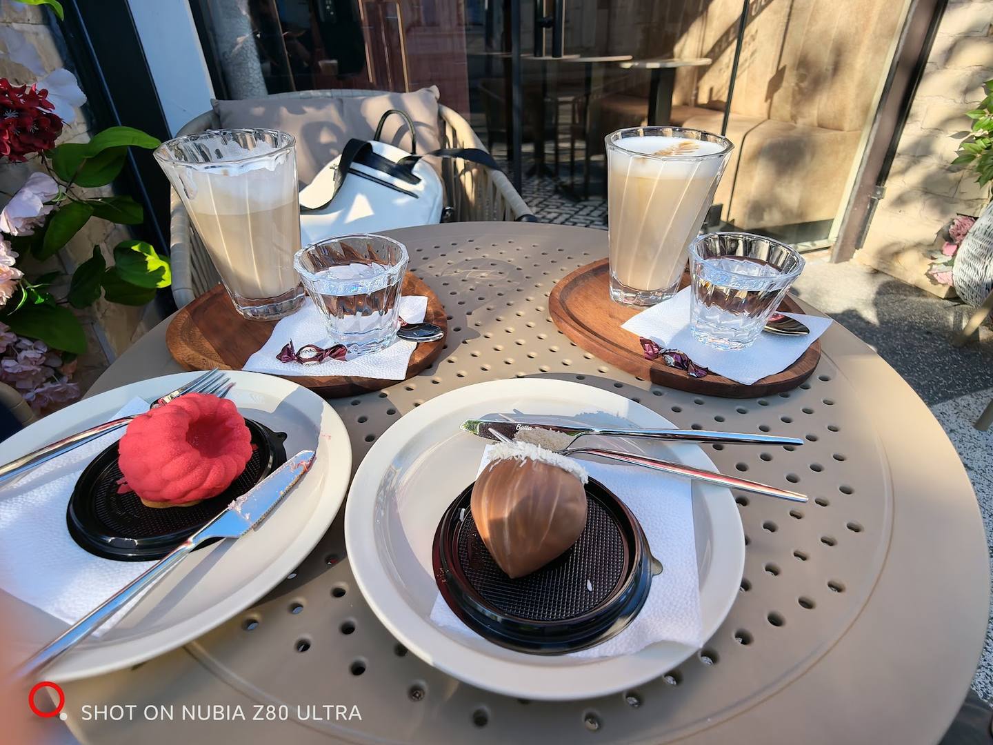 Plated desserts and beverages on a sunny outdoor terrace